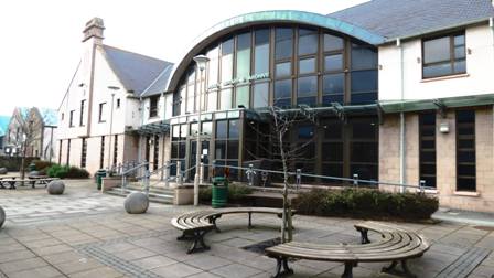 Kirkwall Library with benches to sit on and large balls on the paved area