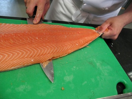 a salmon being sliced up