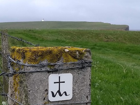 the sign post for the St Magnus Way with the cross and wavy line under it