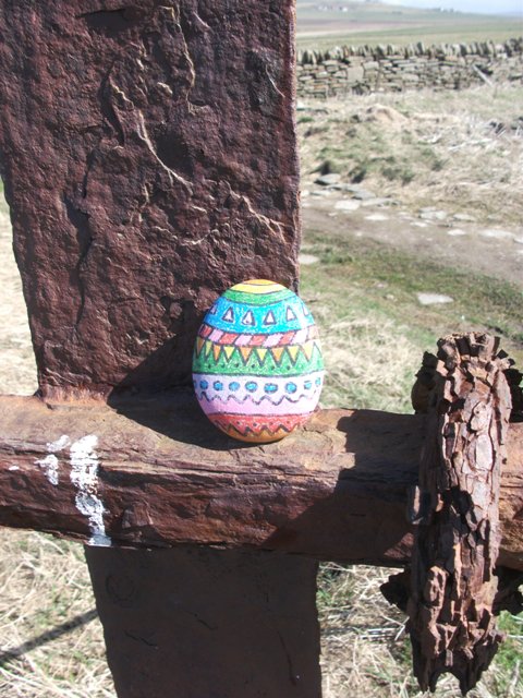 a painted stone like an Easter egg up against a stone slab on the cliffs at Marwick Head