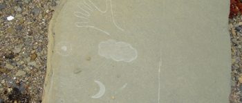 a stone with the mark of a hand scratched into it