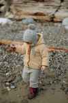 a young child dressed for the outdoors with a woolly hat and jacket and trousers on