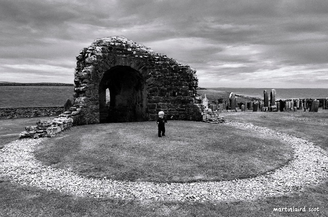 the remains of the round church in Orphir with a small child standing in the centre