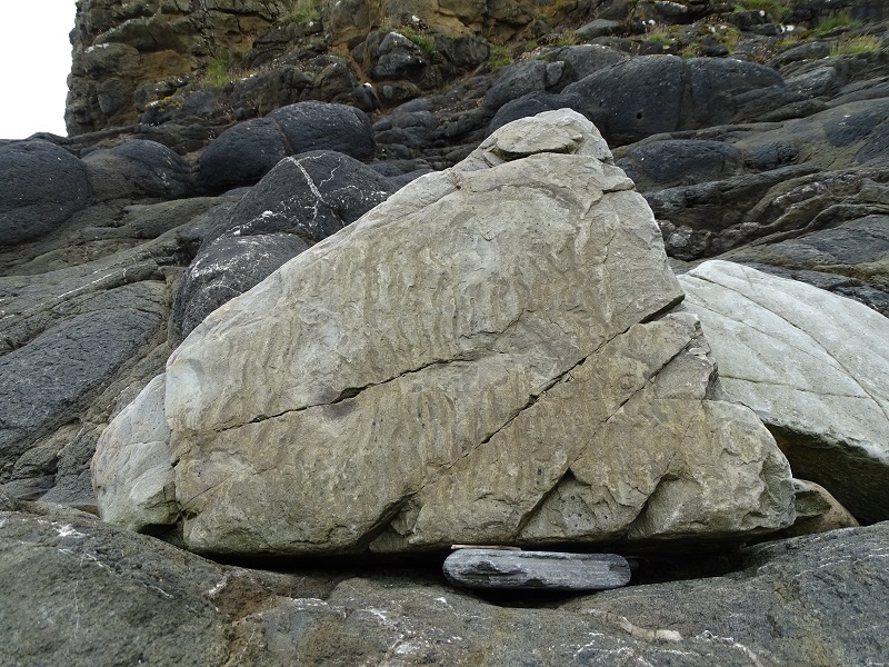 a triangle shaped stone on the beach