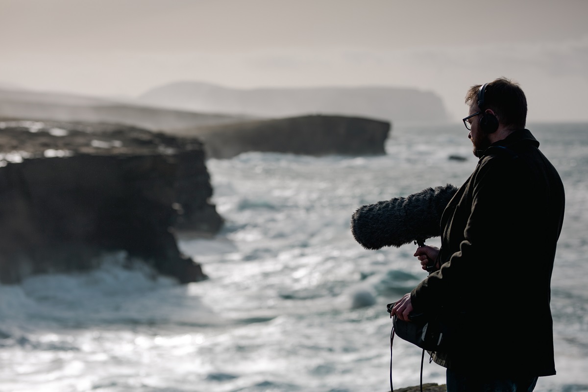 Brian Cromarty picture on the cliffs with a large recording device