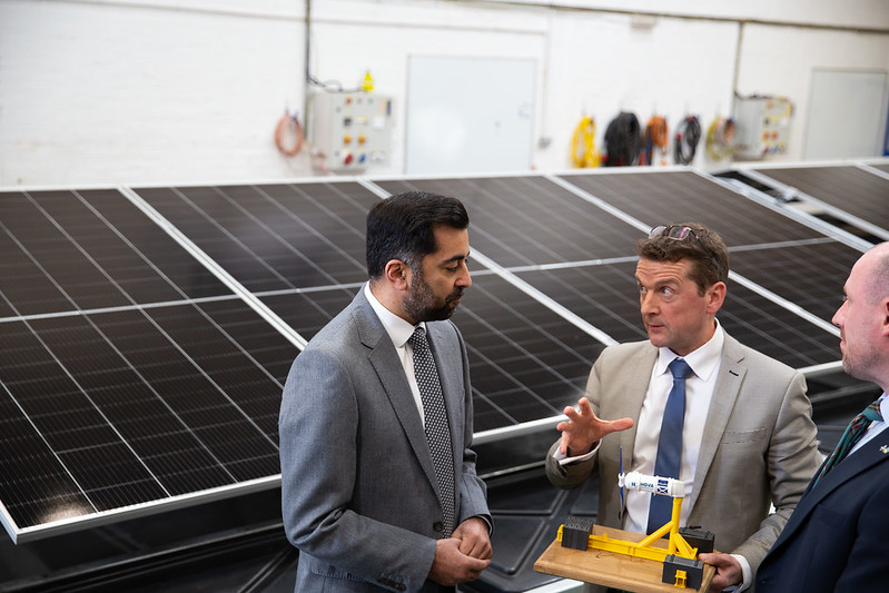 Humza Yousaf at Nova Innovation in front of an array of very large solar panels