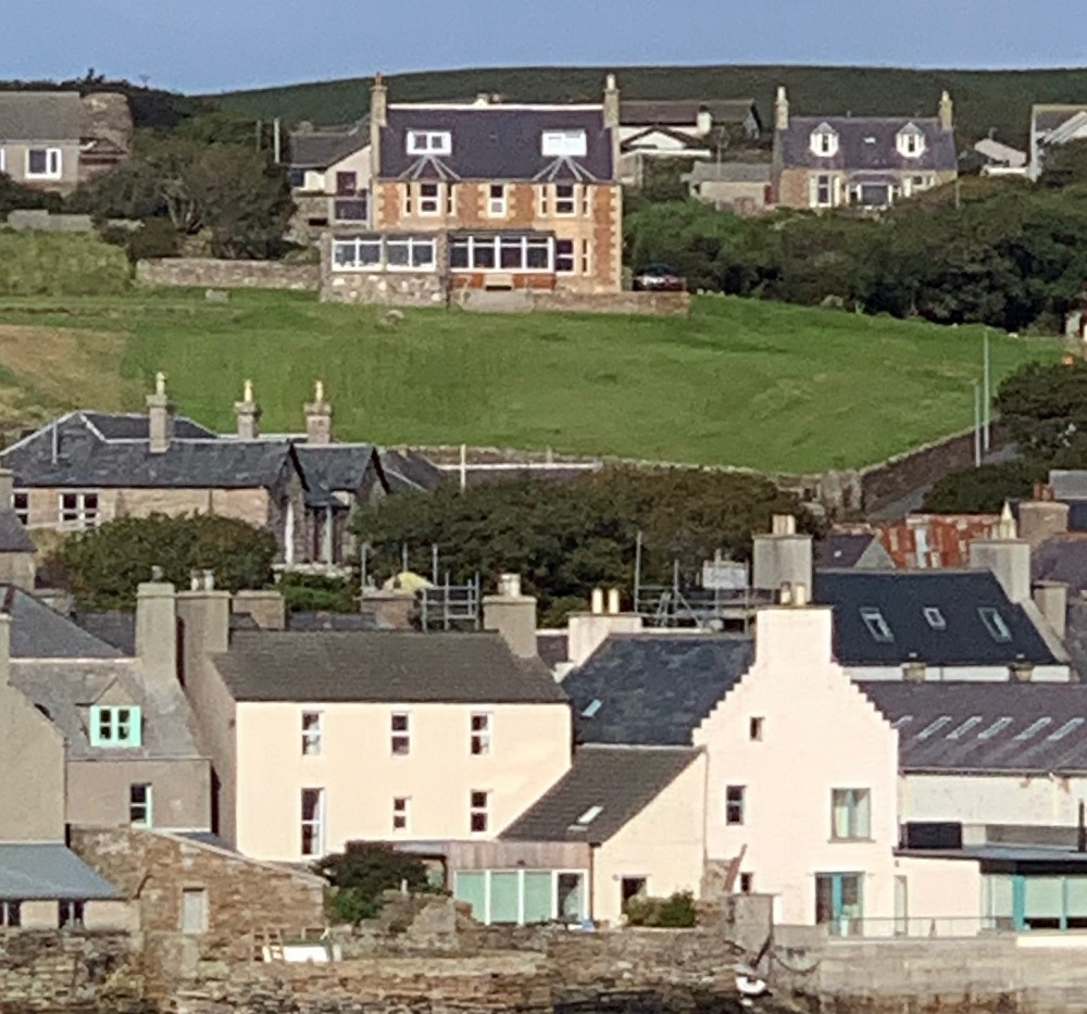 the buildings of Stromness marching up the hill overlooking the bay