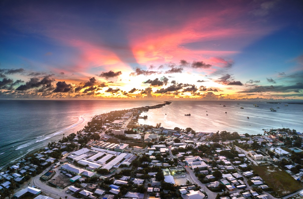 an aerial photo at sunset of the extremely densely packed capital city of Majuro as it streams out into the surrounding sea