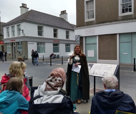 Raggie explaining to the seated tour company at the corner of Castle Street