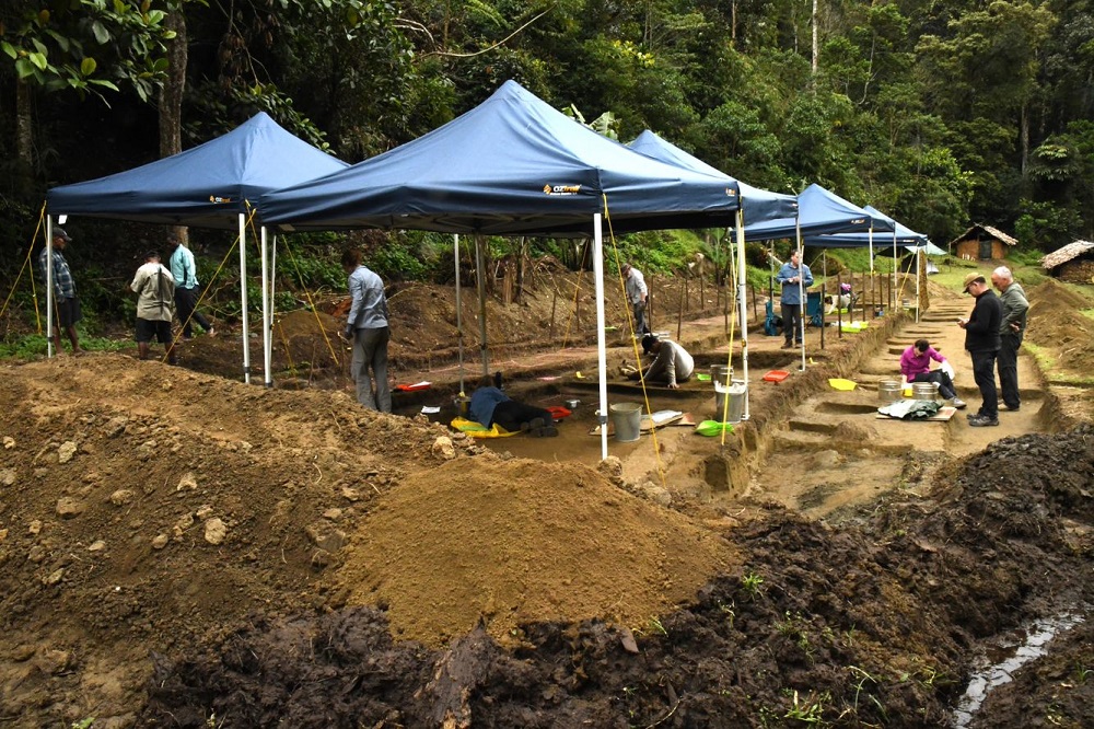 the archaeological dig at the jungle site of Templetons Crossing. Covered canopies shelter the site as archaeologists carefully work beneath them to uncover the remains of Australian soldiers