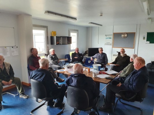 large group of men sitting around the room