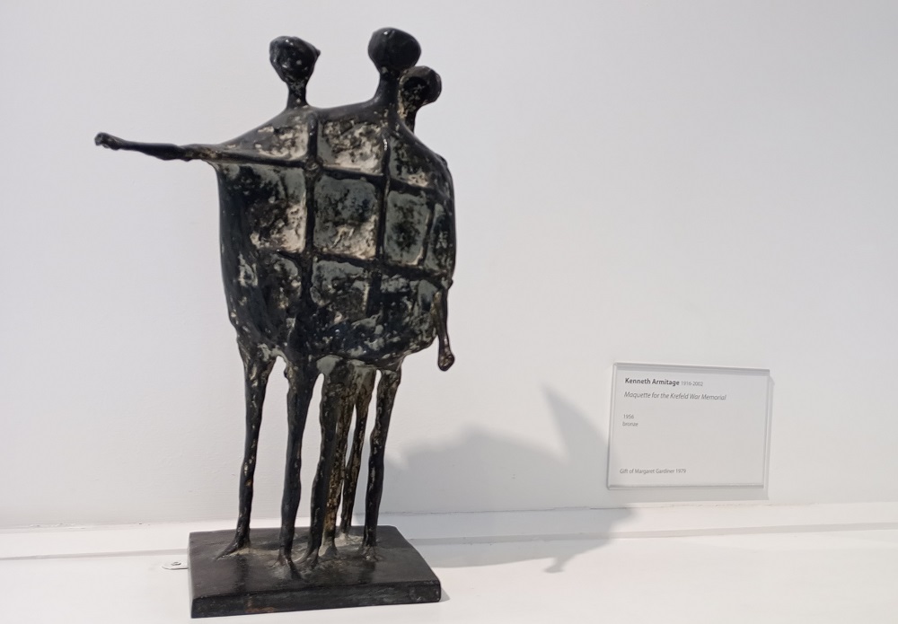 a design for a war memorial show three figures standing one with arm outstretched. Thin legs and bodies moulded together with grid lines across them