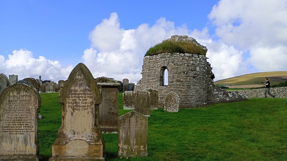 looking across the old gravestones to the remains of the round church at the Bu Orphir