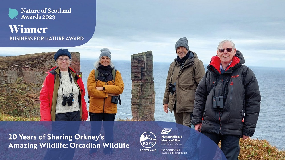 a group of very happy wildlife tourists on Hoy with The Old Man of Hoy sea stack in the background