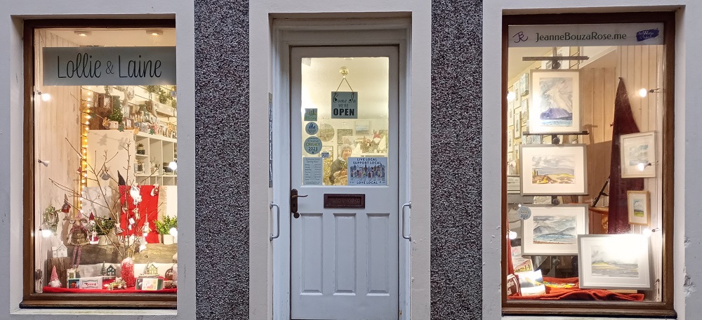 a Stromness shop window decorated for Christmas with little hanging santas