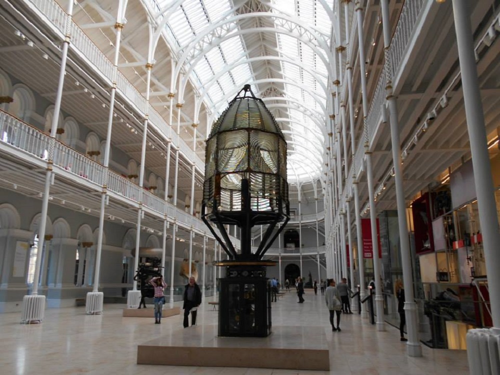 inside the grand entrance of the National Museum of Scotland in Edinburgh with a large lighthouse light