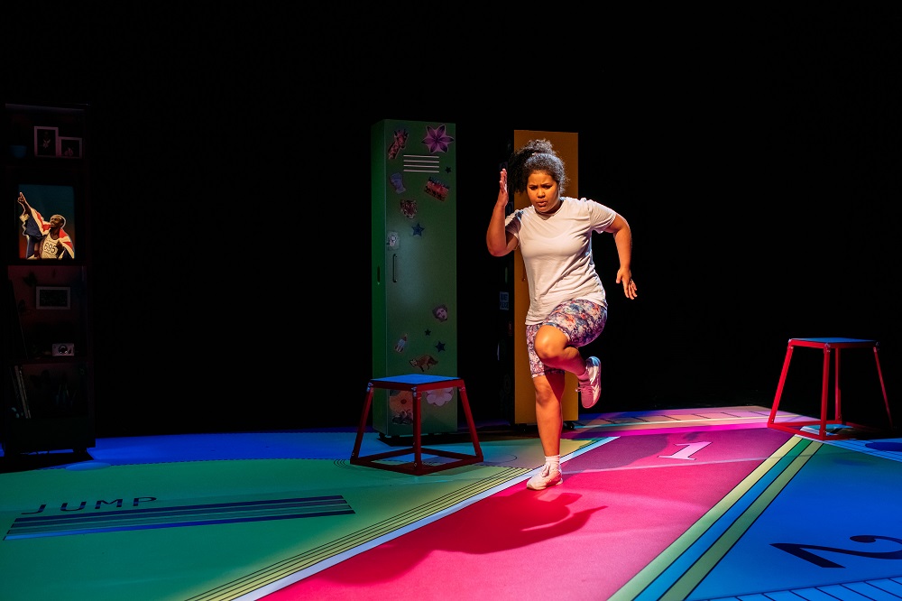 a young girl sprints along a track
