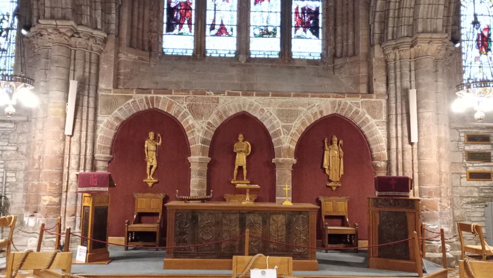 St Rognvalds Chapel with the three wooden figures on the wall behind telling the story of the cathedrals planning and construction