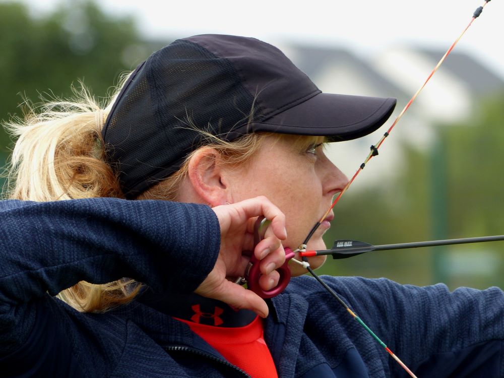 close up of face of woman archery concentrating as she gets ready to shoot