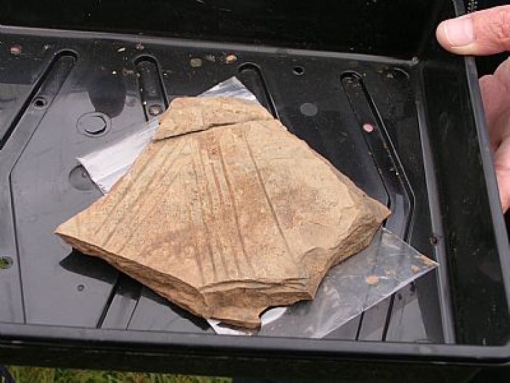 sherd of pottery with pattern of lines on it