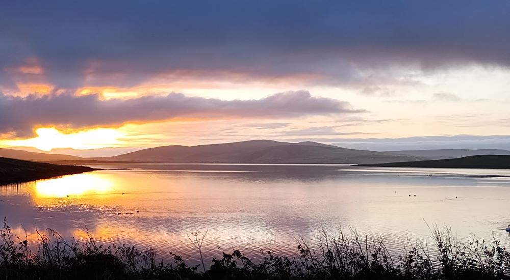 sunrise over a calm and still Stenness Loch