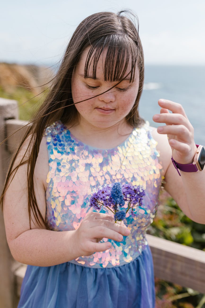 a girl holding purple and blue flowers