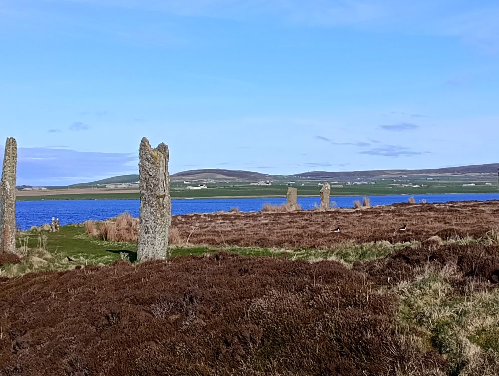 the standing stones of the Ring of Brodgar, the Harry Loch in the distance