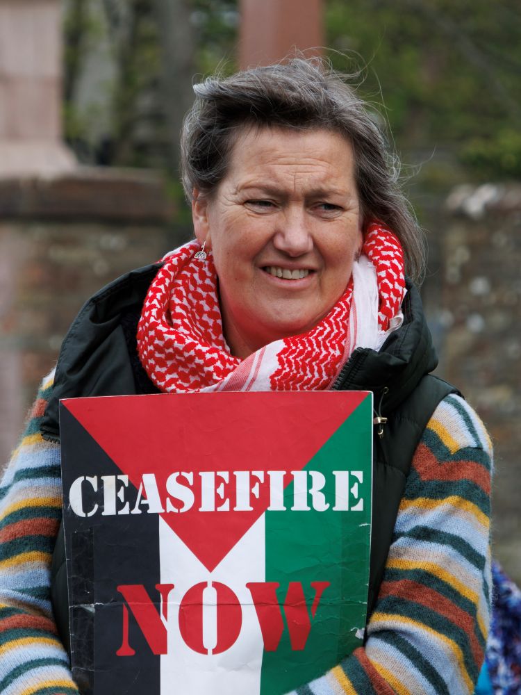 a woman holding a ceasefire poster