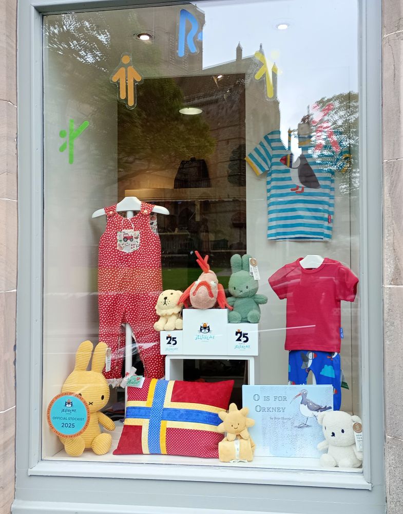 the shop window dispaly for the Island Games with kids clothes and a little podium with medal winning toys