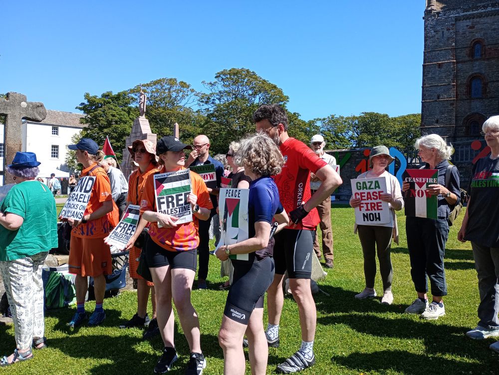 group of people some wearing sports outfits for the Island Games at the vigil
