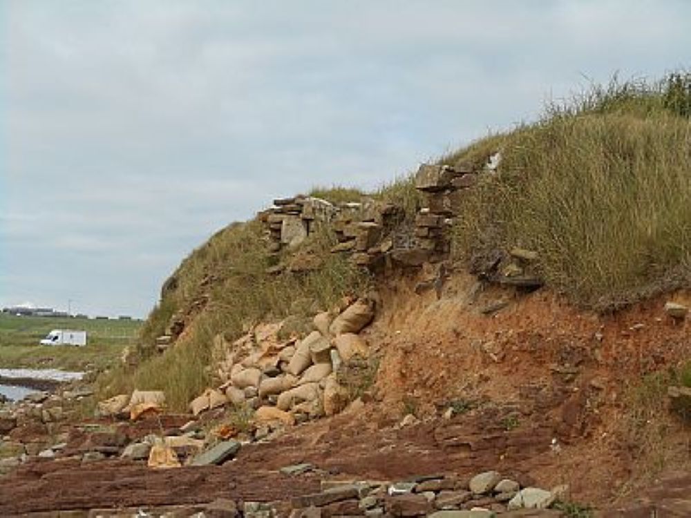 the eroding coastline with stones tumbling down