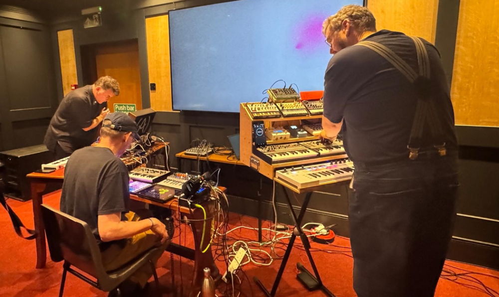 two men working away at sound equipment and keyboards