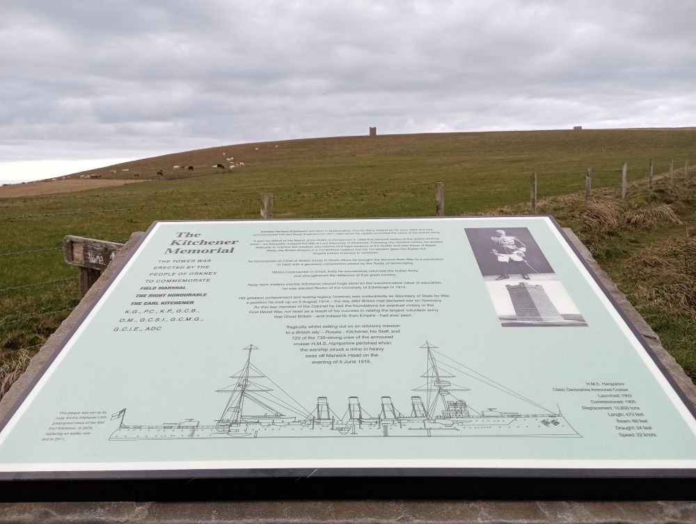 Information board at the walk up to the Kitchener Memorial At Marwick Head with the tower of the memorial on the horizon