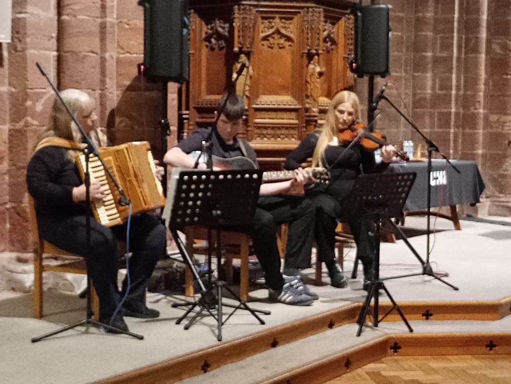 one person on accordion, one on guitar and one on violin
