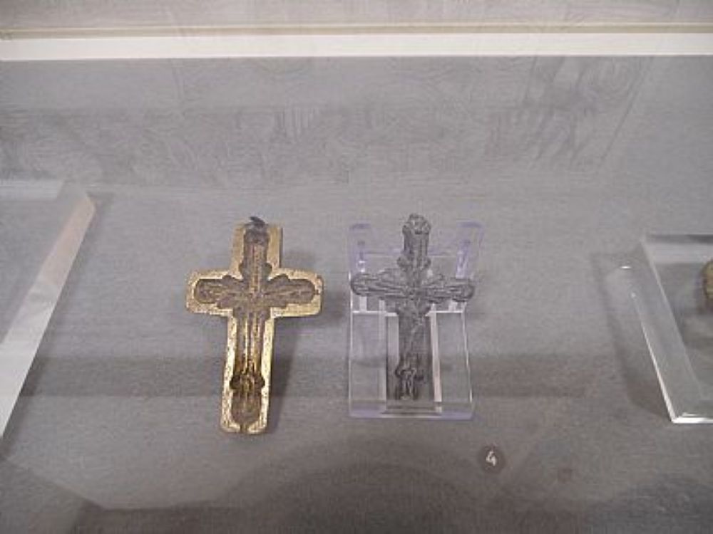 a cross in a display case and the mould beside it