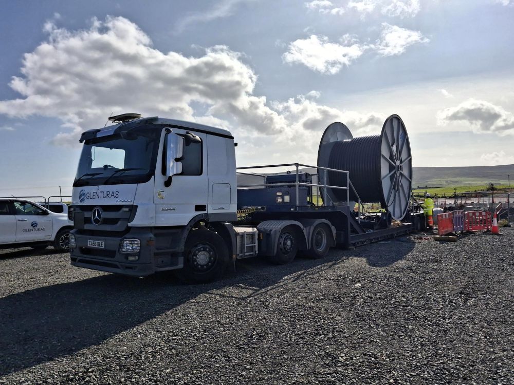 Lorry with large cable roll on land
